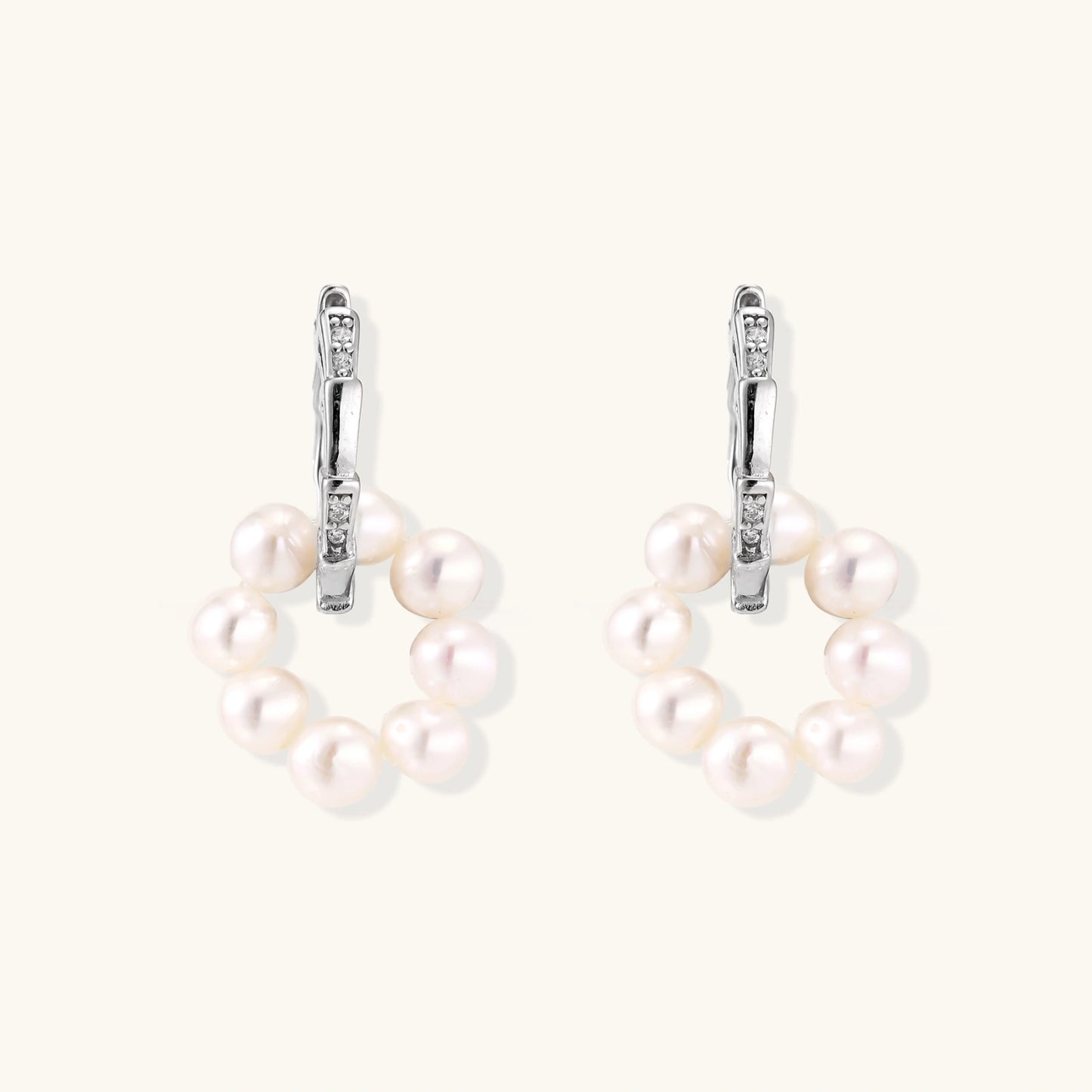 Rhodium-plated silver hoop earrings with freshwater pearls arranged in crescent formation and diamond accents