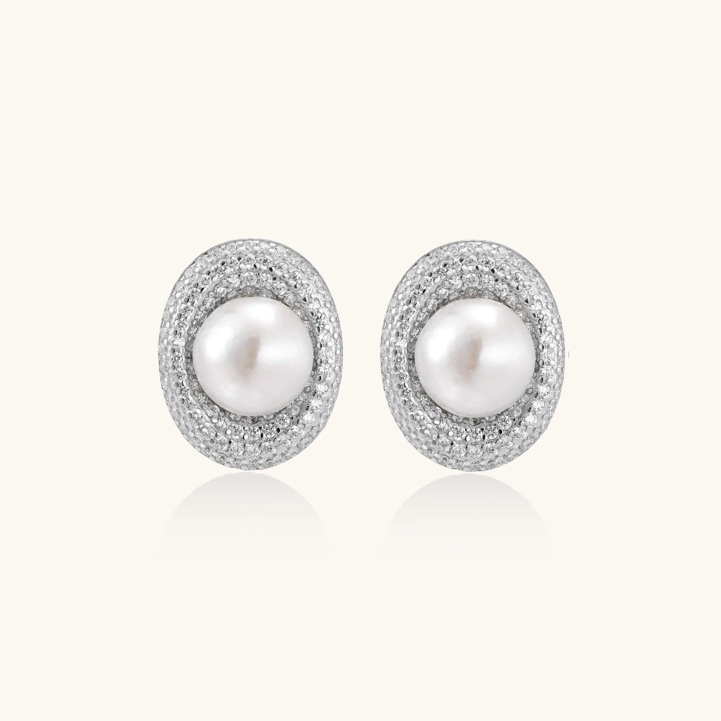 Elegant stud earrings with cream freshwater pearls surrounded by sparkly pavé crystals on rhodium-plated silver setting