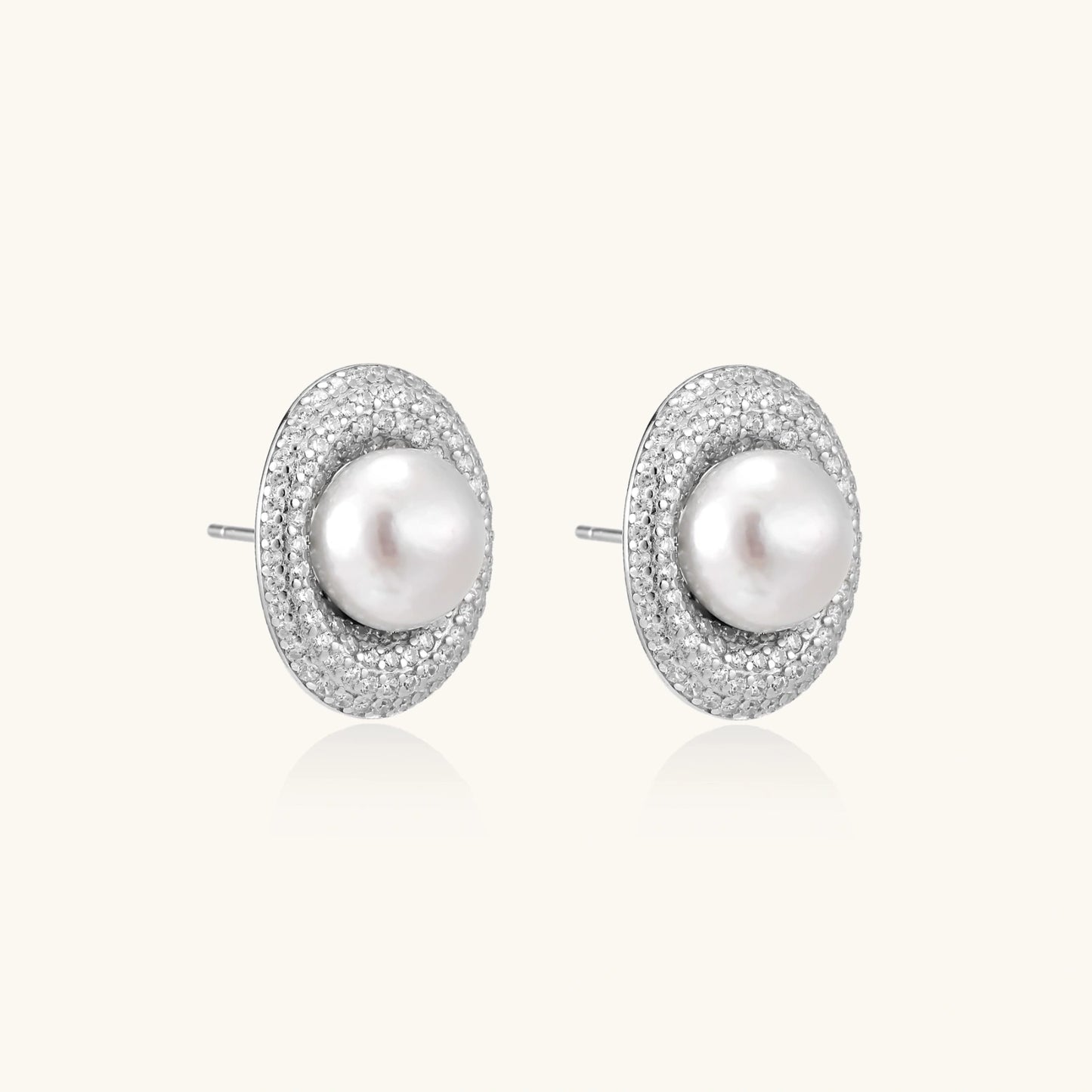 Elegant stud earrings with cream freshwater pearls surrounded by sparkly pavé crystals on rhodium-plated silver setting